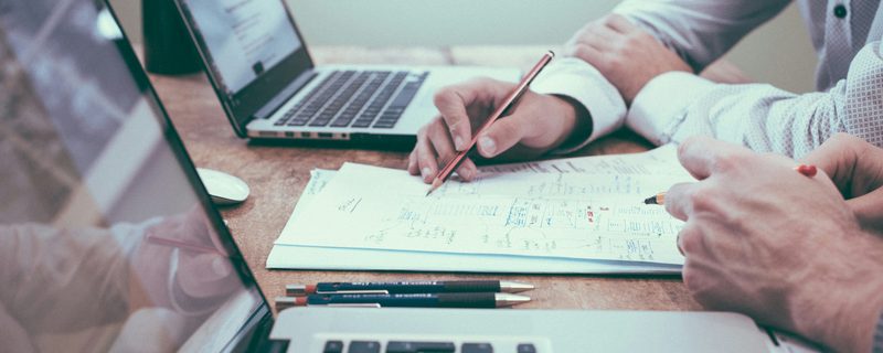 Printed reports and notes spread across a desk